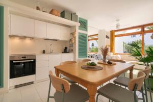 een keuken en eetkamer met een houten tafel en stoelen bij Lanzarote Beach Apartments, CASA BRUNA in Costa Teguise