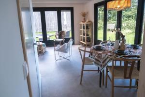 a dining room with a table and chairs and windows at Duinhuis Zout Hout in Egmond-Binnen +47 photos