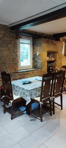 a dining room table with two chairs and a stone wall at Coeur de granit rose, meublé alliant le charme de l'authentique breton et du confort, classé 3 étoiles, à 5mn de 13 plages de la réputée cote de granit rose in Trégastel