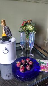 a table with a blue plate of strawberries and wine glasses at Hilltop Inn in Newport