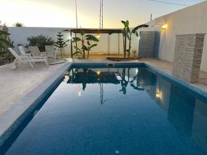 a swimming pool with blue water in a house at Dar aissa in Aghīr