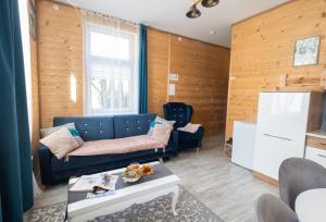 a living room with a blue couch and a table at Apartamenty pod Kicarzem in Piwniczna-Zdrój