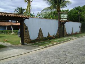 a wall with a sign next to a street at Guest House Green Garden in Búzios