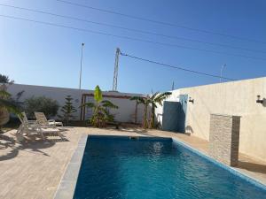 a swimming pool in front of a house at Dar aissa in Aghīr