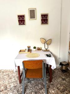 a table with a chair and a white table cloth at Chambre Djaou meublée Voidjou in Batsa