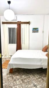 a bedroom with a white bed and a window at Chambre Djaou meublée Voidjou in Batsa