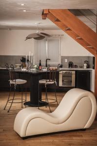 una cocina con un banco en el medio de una habitación en Superbe appartement loveroom avec balnéo Dolce notte, en Carbonne