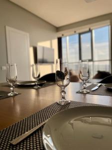 a table with wine glasses and a plate on it at Coliseum Palace Panorama View in Chişinău +8 photos