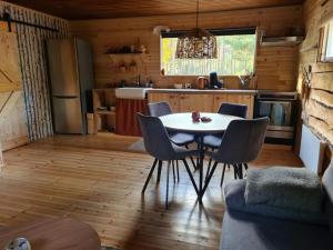 eine Küche mit Tisch und Stühlen in einem Zimmer in der Unterkunft Stuga Solros in Gräsmark + 12 Fotos