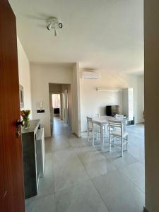 Una cocina y una sala de estar con mesa y sillas. en Dalla Irma Appartamento Vacanze Bellaria, en Bellaria-Igea Marina