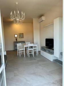 Un comedor con una mesa y sillas y una lámpara de araña. en Dalla Irma Appartamento Vacanze Bellaria, en Bellaria-Igea Marina