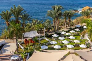 an aerial view of a resort with palm trees and the ocean at Queens Bay Hotel in Paphos