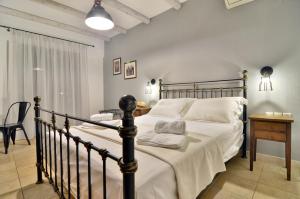 a bedroom with a bed with white sheets and a table at Niriides Luxury Apartments in Syvota