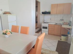 a kitchen with a white table and orange chairs at Stan Marina in Pale