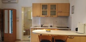 a kitchen with wooden cabinets and a counter top at Apartments Lena in Podgora