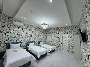 a bedroom with two beds and a wall with logs at Emirate Plaza in Sergeli
