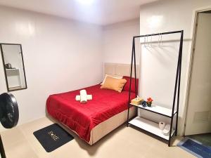 a bedroom with a red bed with a mirror at D' Affordable Quarters in Santa Barbara