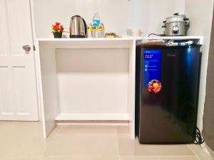 a black refrigerator in a kitchen next to a counter at D' Affordable Quarters in Santa Barbara