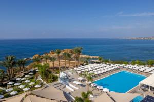 an aerial view of a resort with a pool and umbrellas at Queens Bay Hotel in Paphos
