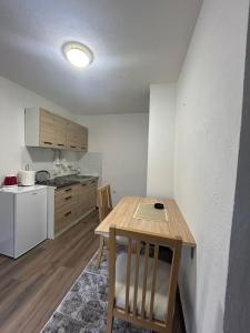 una pequeña cocina con una mesa de madera en una habitación en Apartments Elida, en Sarajevo