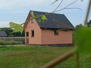 a small house with a black roof at Winnica Zatorska in Olszyny