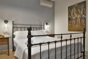 a bed in a bedroom with a painting on the wall at Niriides Luxury Apartments in Syvota