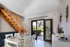 a white dining room with a white table and chairs at Residence il Melograno in San Teodoro