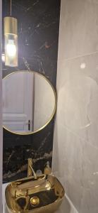 een badkamer met een gouden wastafel en een spiegel bij Luxury Apartment Paper in Zagreb