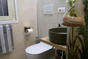 ein Badezimmer mit einem grünen Waschbecken und einer Toilette in der Unterkunft Dimora Vantaggio in Rom + 4 Fotos