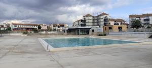 una piscina vacía frente a algunos edificios en Appartement Cosi Place Martinique, en Le Barcarès