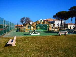 un parque con parque infantil con bancos en el césped en Appartement Cosi Place Martinique, en Le Barcarès