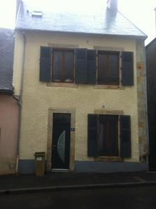 a house with blue shuttered windows and a door at Villa Boston in La Bourboule