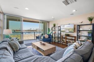 a living room with a couch and a table at Stunning Bayfront condo with gorgeous views, garage, massive roof deck & AC - dogs welcome! in San Diego