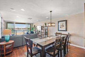 a dining room and living room with a table and chairs at Stunning Bayfront condo with gorgeous views, garage, massive roof deck & AC - dogs welcome! in San Diego