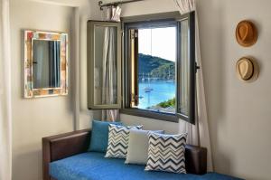 a room with a window with a blue couch and a view at Niriides Luxury Apartments in Syvota