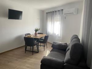 a living room with a couch and a table with chairs at El Rincón del Mirador in Carboneras de Guadazaón