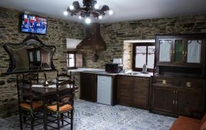 a kitchen with wooden cabinets and a table and a mirror at Casa Mameleiro e Casa Kintal in A Pontenova