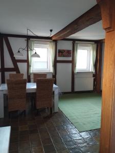 a dining room with a table and two windows at Ferienwohnung Wechterswinkel in Bastheim +4 photos