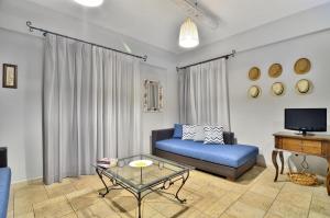 a living room with a blue couch and a table at Niriides Luxury Apartments in Syvota