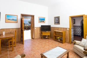 a living room with a couch and a tv at Casa Seña Catalina, antigua casa típica canaria in La Oliva
