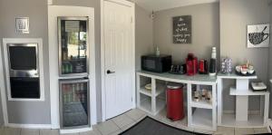 a kitchen with a counter with a microwave and a refrigerator at Mystic Isle Motel in Wawa