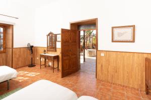 a room with a bed and a desk and a door at Casa Seña Catalina, antigua casa típica canaria in La Oliva