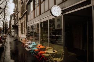 un groupe de tables et de chaises à l'extérieur d'un bâtiment dans l'établissement Ferdinands Gateaway inkl Breakfast, à Berne