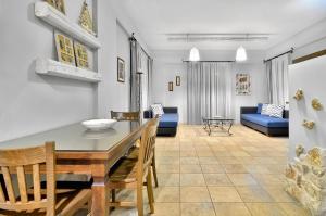a dining room and living room with a table and chairs at Niriides Luxury Apartments in Syvota