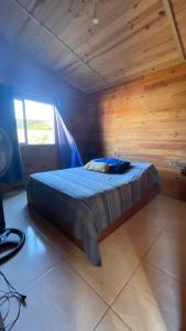 a bedroom with a bed in a wooden room at Casa Violeta Punta del Diablo in Punta Del Diablo