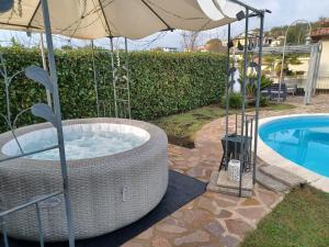 a hot tub with an umbrella next to a pool at Boville Family House in Boville Ernica