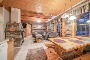 a living room with a table and a stone fireplace at Kiiruna by Aavalevi Holidays, Levi Center in Levi
