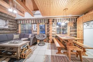 a living room with a couch and a table at Kiiruna by Aavalevi Holidays, Levi Center in Levi +20 photos
