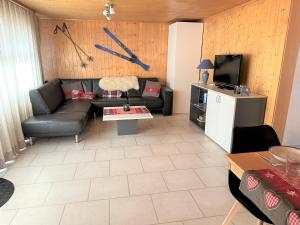 贝特默阿尔卑Ski-in, central and cosy in the Chalet Diana, free access to swimming pool的带沙发和桌子的客厅