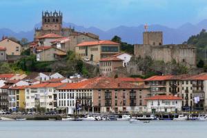 a city with buildings and boats in the water at Apartamentos Villa Sofía in San Vicente de la Barquera